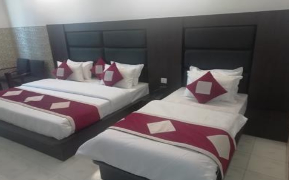 Room with double and single beds at Hotel Malabar Inn